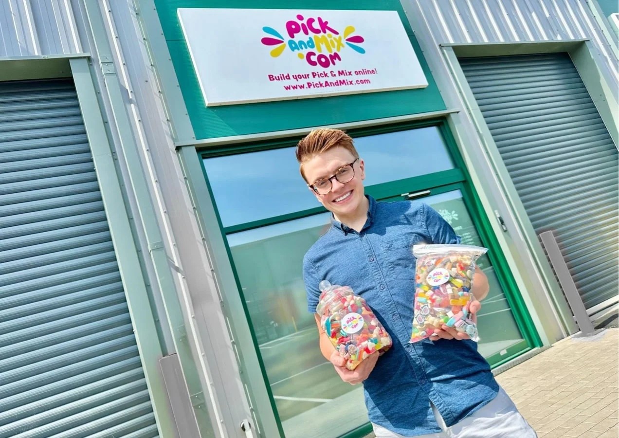 PickandMix team members standing in front of a building holding bags of candy