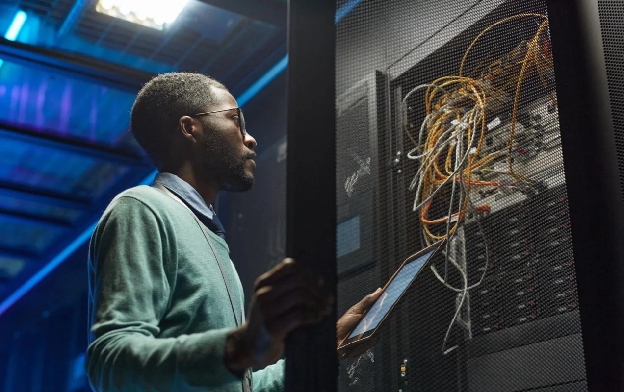 man working on a server with a tablet