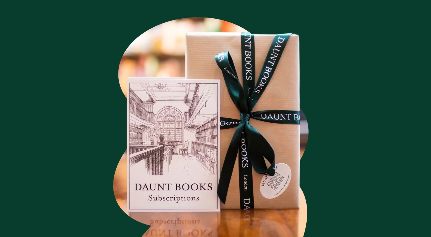 a photo of a craft paper-wrapped box with green ribbon and a card that reads "Daunt Books" on a dark green background