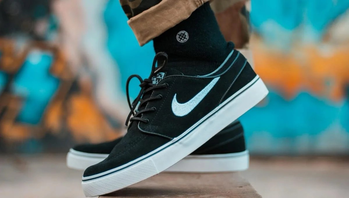 black Nike tennis shoes with a colorful background